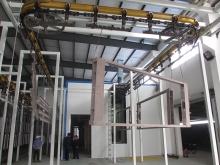 Powder spraying line for frame parts